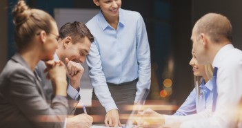 smiling female boss talking to business team