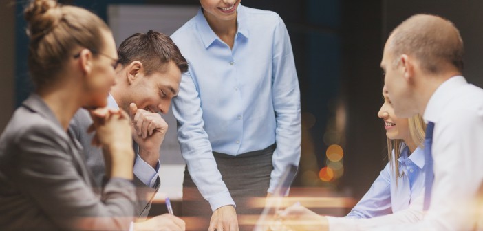 smiling female boss talking to business team