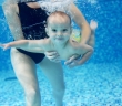 Little boy learning to swim in a swimming pool