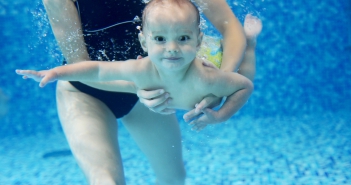 Little boy learning to swim in a swimming pool