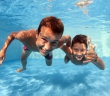 Underwater brothers portrait in swimming pool.