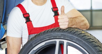 Master mechanic shows thumb up in a garage